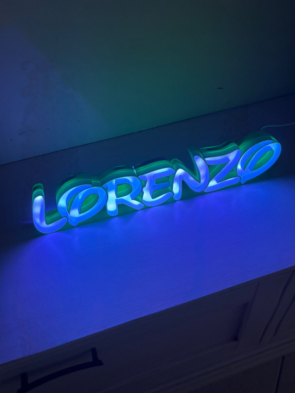 Lampada con nome Lorenzo vista di lato con luce blu e verde