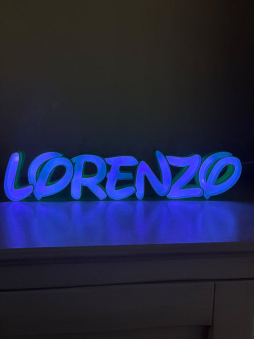 Lampada con nome Lorenzo in lettere 3D illuminate di blu su un mobile